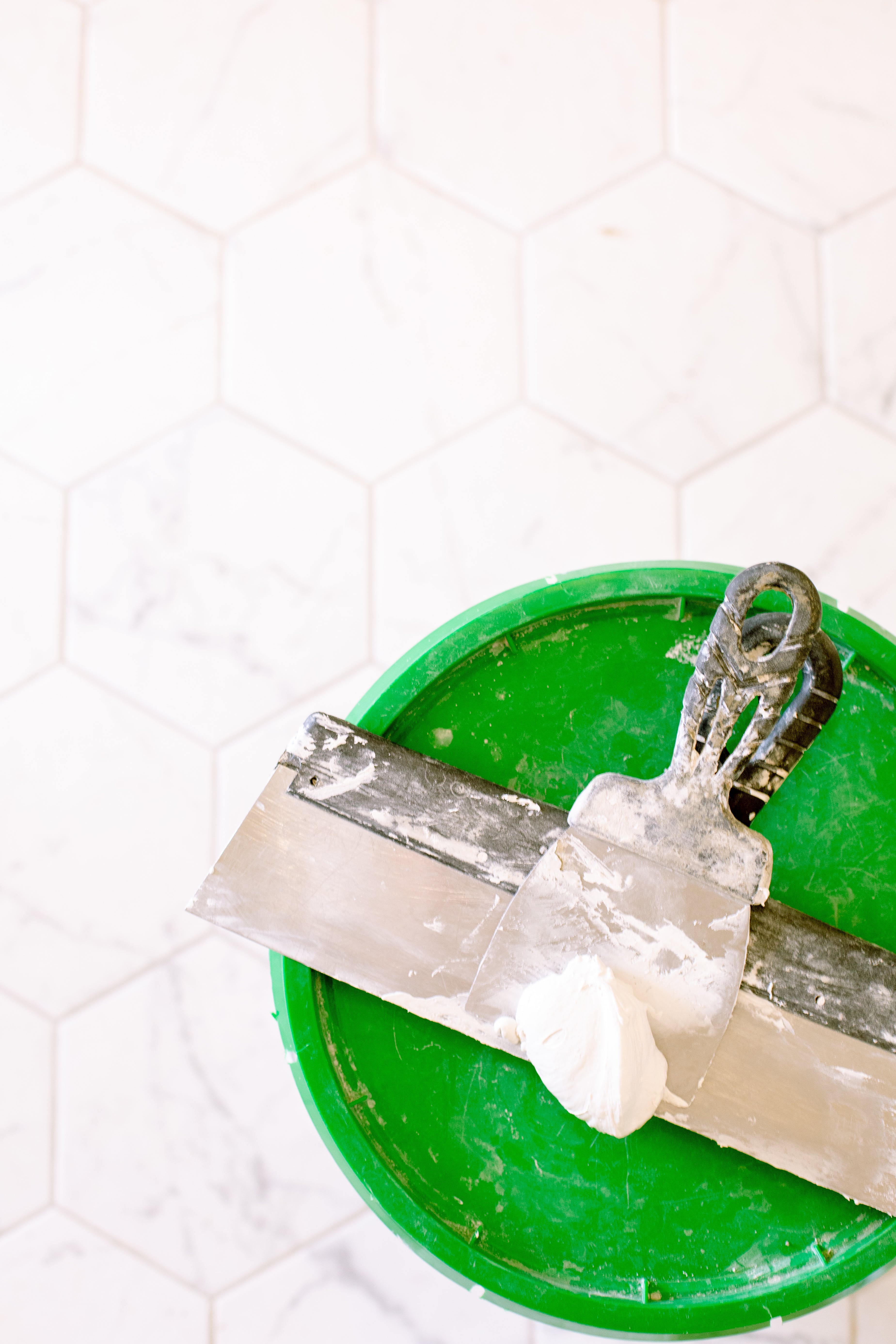 Bucket with caucking and tile in background